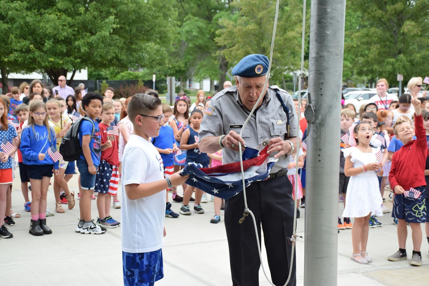 Jim Morge from American Veterans Post 111 in Patchogue and student Brody raise the flag during the Flag Day ceremony at Sylvan Avenue Elementary School.